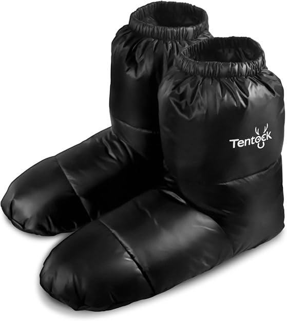 Insulated winter camp slippers resting on a rustic wooden surface, designed to keep feet warm during cozy camping nights in cold weather.